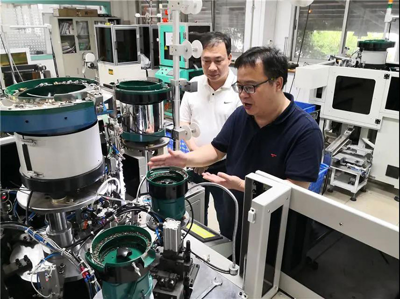 華圣達技術設備中心研發(fā)人員(右)在介紹自主研發(fā)的智能生產(chǎn)拉鏈機械設備 華圣達技術設備中心研發(fā)人員(右)在介紹自主研發(fā)的智能生產(chǎn)拉鏈機械設備